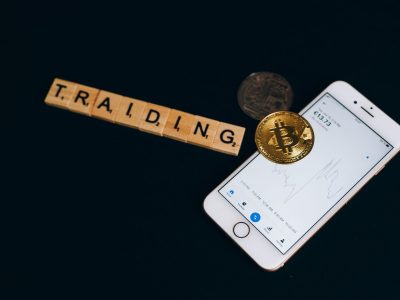 Bitcoin sikkesi, kripto uygulaması açık bir telefon ve harf taşları
