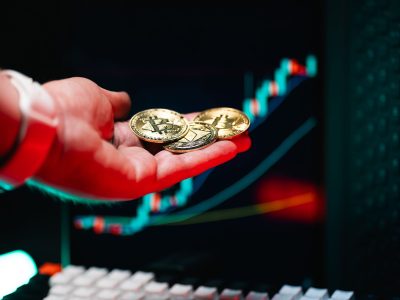 Avuç içinde Bitcoin ve Ethereum sikkeleri, arkada yükselen fiyat grafiği