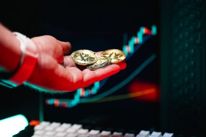Avuç içinde Bitcoin ve Ethereum sikkeleri, arkada yükselen fiyat grafiği